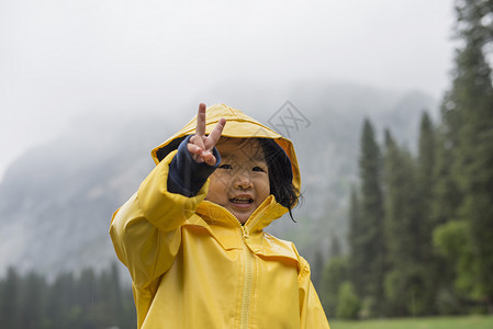 穿着黄色雨衣的蹒跚学步的女宝宝背景图片