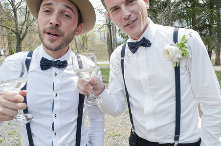 在婚礼上拿着葡萄酒杯庆祝的男子图片