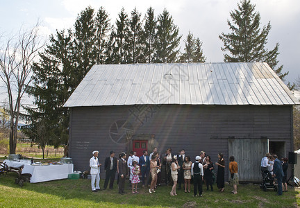 一大群婚礼嘉宾聚集在谷仓外背景图片