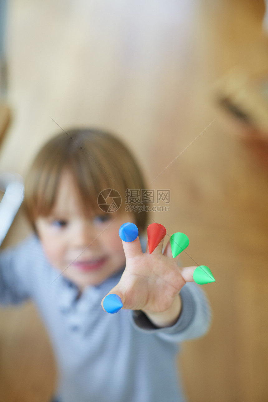 男孩手指上套着亮彩色的玩具图片