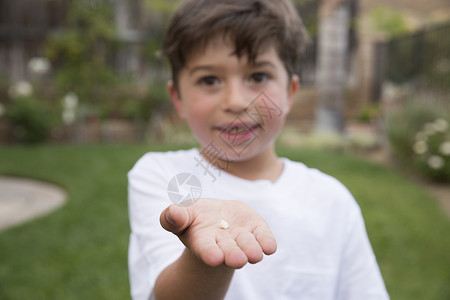 对手握着牙齿的年轻男孩肖像专心手动背景图片