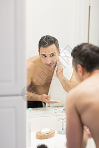 使用剃须刀刮胡子的男性背景图片