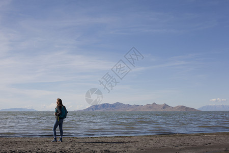 美国犹他州大盐湖站在水边向外眺望的年轻女子的后视图图片