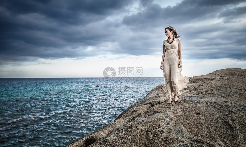 在意大利撒丁岛科斯塔赖伊悬崖顶上漫步的年轻女子图片