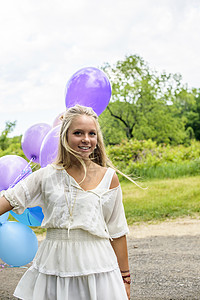 在农村公路上装满气球的年轻美女肖像图片