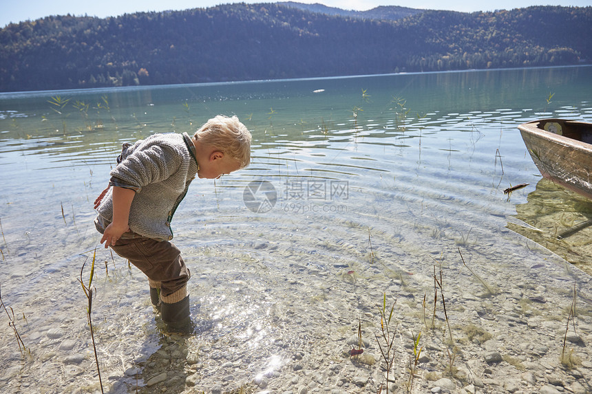 男孩在湖边划艇看着湖图片