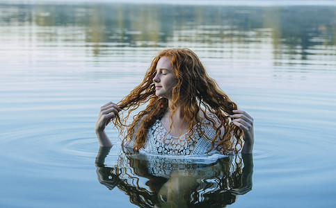 半身浸入湖水的年轻女性形象女的高清图片素材