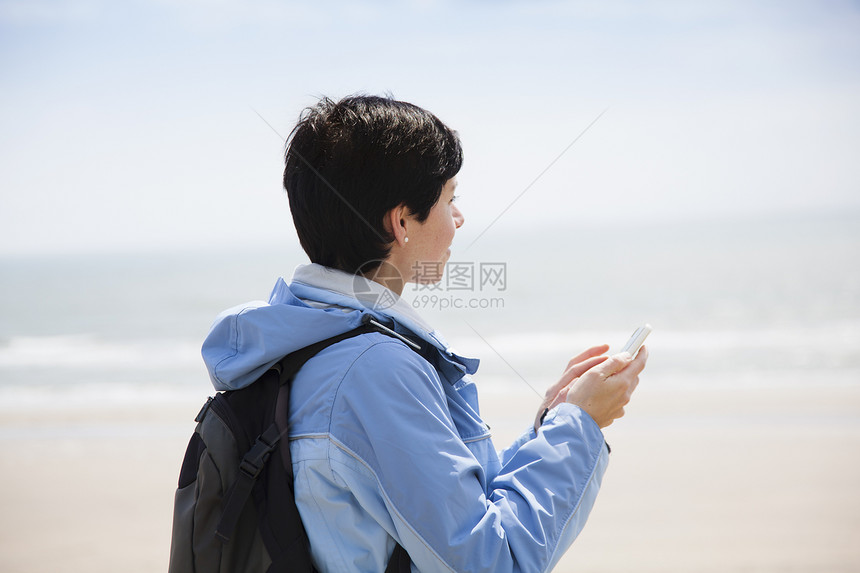 女子在海滩上用手机图片