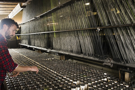 男织工在纺织厂使用旧织机图片