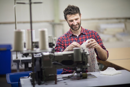 在旧纺织厂使用缝纫机的男纺织设计师幸福高清图片素材