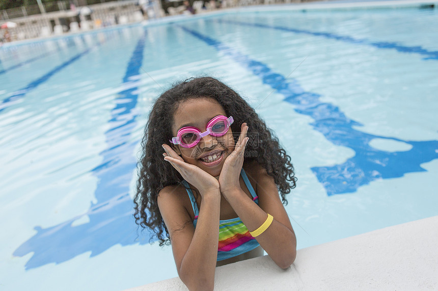 泳池中女孩的肖像穿着游泳护目镜看着头微笑图片