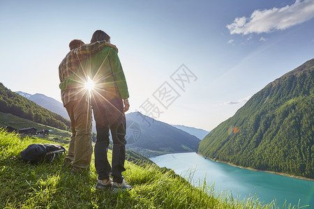 施奈尔靴在Vernagt水库和Finailhof农庄外望风的年轻夫妇意大利南蒂罗尔州ValSenales背景