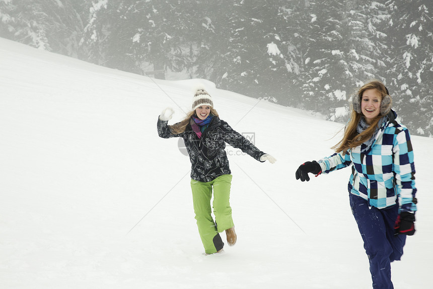 在雪中玩耍的年轻妇女奥地利蒂罗尔Sattelbergalm图片