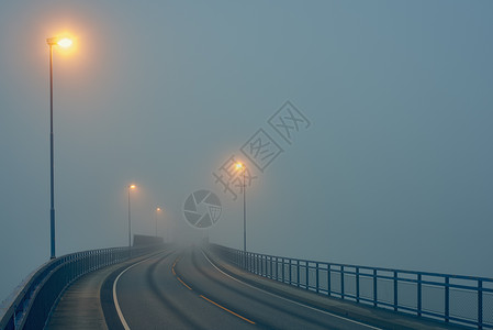 挪威罗加兰县豪格松街道灯光照明下迷雾道路的渐弱透视图背景