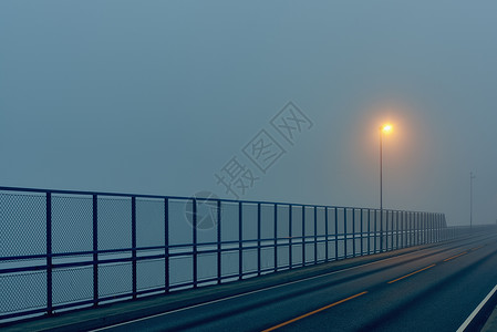 豪格松挪威罗加兰县Haughesund路灯照亮的清空公路和安全屏障背景