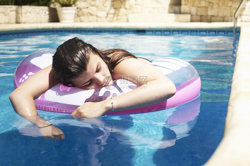 少女在游泳池的充气式上漂浮图片