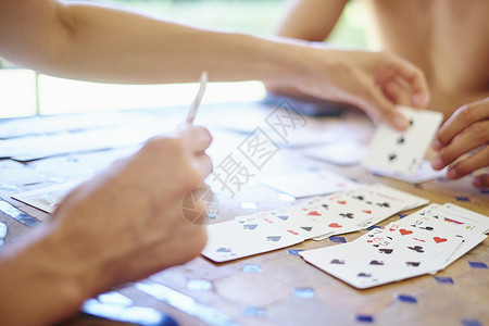 成人和儿子在桌边打牌的特写背景图片