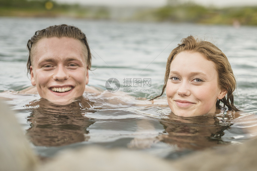 在温泉池子里微笑的夫妇图片