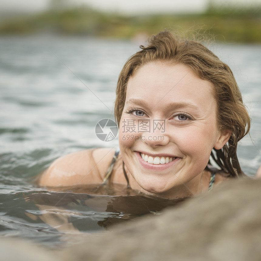妇女独自一人在温泉池里微笑着看镜头图片