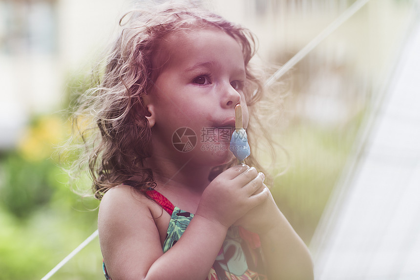 女孩在花园里吃冰棒图片