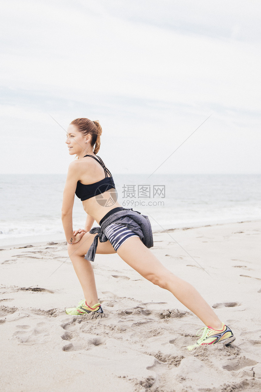 成年女人在沙滩上伸展的肖像图片