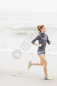 成年妇女沿沙滩奔跑高清图片