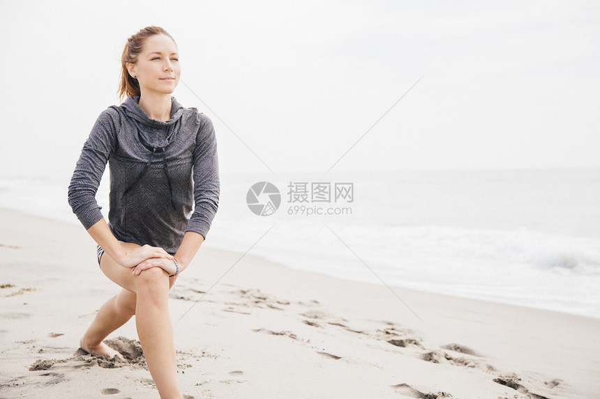 成年妇女在沙滩上拉伸图片