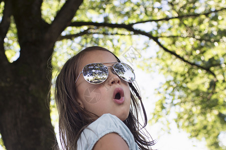 小女孩在树下戴着墨镜图片