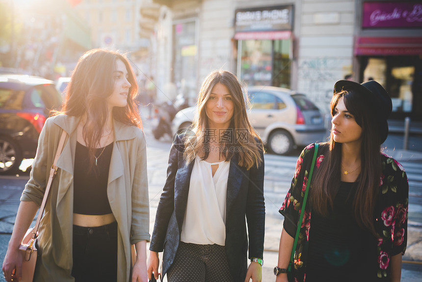 三名年轻妇女在市街上漫步图片