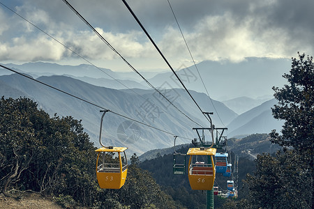 云南丽江牦牛牧场的山脉和黄色缆车高清图片