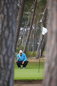 蹲下休息的高尔夫球手图片
