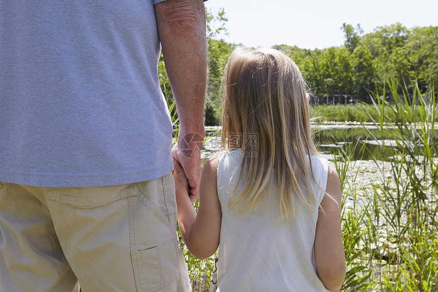 农村湖边手握的女孩和祖父近视图片