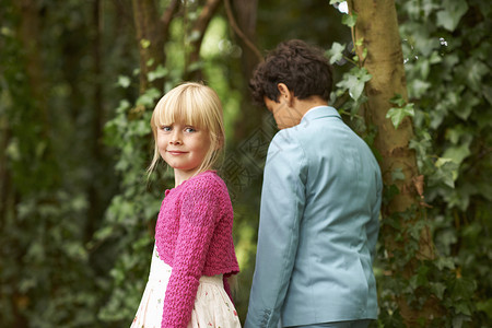 女孩在花园里与男子一起漫步时回头望图片