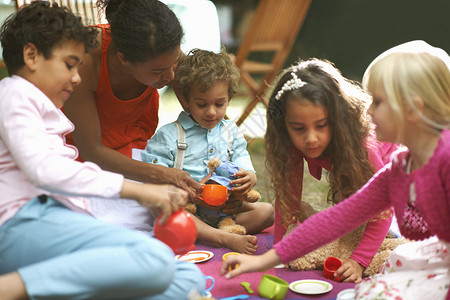 母亲和四个孩子在花园生日派对上玩野餐图片