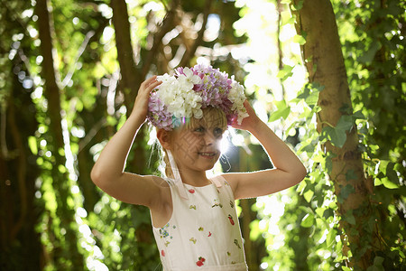 漂亮的女孩在森林里戴着花冠的肖像阳光高清图片素材