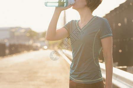 从水瓶饮水的成年妇女图片