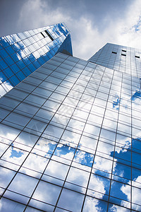 蓝色天空的镜像和玻璃前摩天大楼中的云彩镜像图片
