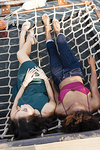 年轻妇女在吊床上放松背景图片