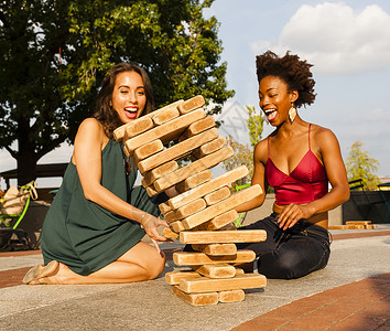 青年妇女在地板上玩抽积木游戏高清图片