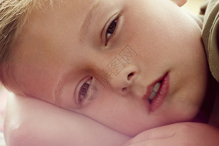 近距离拍摄男孩躺下看着像机的肖背景图片