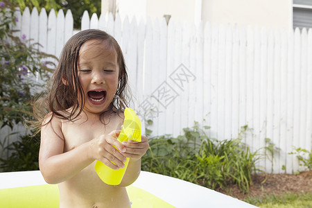 女孩在充气泳池兴奋的玩耍图片
