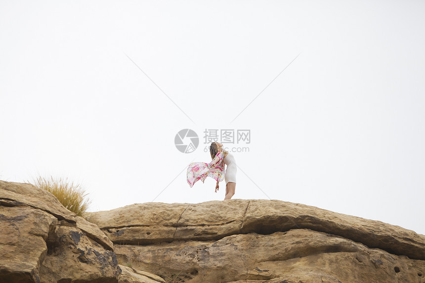岩石上放松的女人图片
