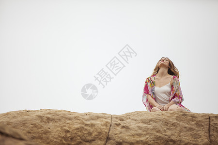 苏珊娜岩石地层上放松的女人背景