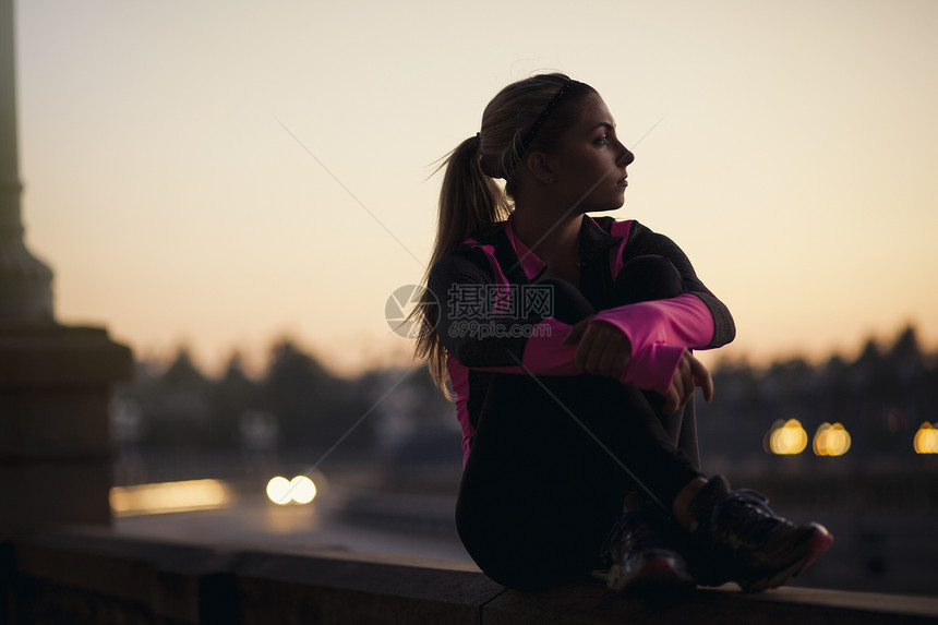 坐在桥上的美女慢跑者图片