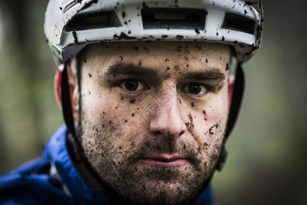 满脸泥土骑脚踏车的男性特写图片