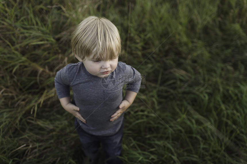 小男孩站在草地上图片