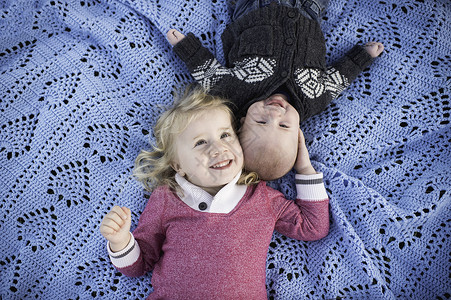 小女孩和小男孩躺在蓝野餐毯上图片