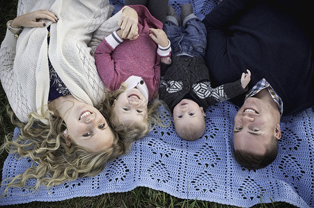 幸福的一家四口躺在野餐毯上图片