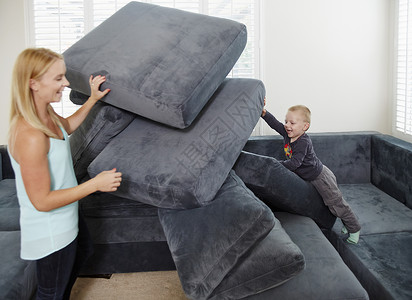 男孩和母亲在客厅沙发玩耍图片