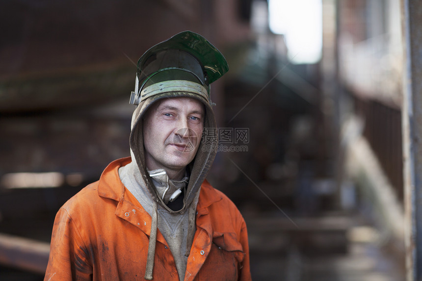 在造船车间戴焊接面罩的工人肖像图片
